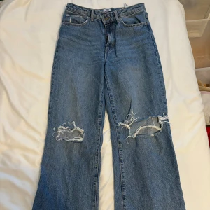 Wide leg jeans - Snygga blåa wide-leg jeans med hål från Lager 157! Använda men inga defekter, high waisted, storlek M och midjemått 38 cm tvärsöver🫶🏼