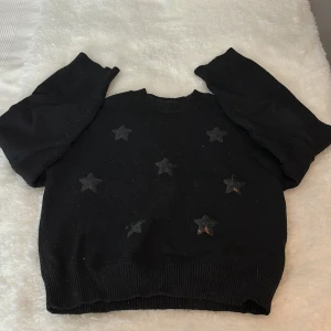 Tröja  - En fin svart stickad tröja med stjärnor på 