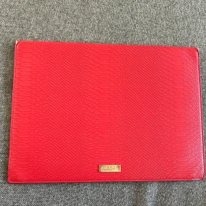 Datorfodral Bianca Ingrosso  - Rött datorfodral från märker by BiancaIngrosso. I bra med använt skick, lite slitet i hörnen och på själva loggan. Storlek: 13”, med måtten: 35x25x2 cm. #datorfodral #bianca #biancaingrosso #bybianca #bybiancaingrosso