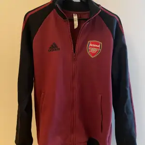 Arsenal tröja/jacka, modell Tiro Anthem  Skick 9/10, väldigt lite använd  Köpt på Adidas hemsida, nypris 799kr
