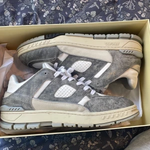 Axel Arigato Sneaker  - Riktigt fina Axel Arigato Skor (Area Lo Sneaker) i den gråa färgen, Storlek 43. Sparsamt använda då jag använde de ett fåtal gånger förra sommaren. Nypris  3 lax, Original Box✅ Dustbag✅ Billigare vid snabbaffär🤩🤝