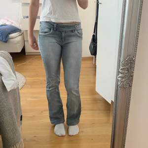 Jättesnygga lågmidjade jeans i ljusblå/grå, storlek 36/S med fina detaljer! Köpta second hand och välanvända men forfarande i väldigt bra skick