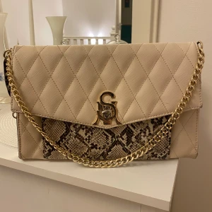 Steve Madden väska - Väska från Steve Madden i Beige, kan användas både som crossbody och axelväska, fint skick och rymlig väska.