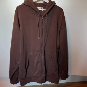 Brun hoodie som är väl använd. Det är lite fläckar på den från blekningsmedel, därav det låga priset!