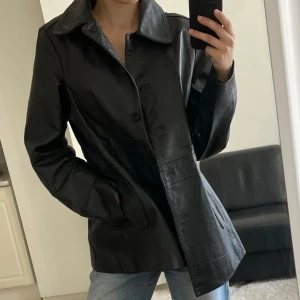 Svart läderjacka  - Svart Vintage läderrock i bra skick!   Ingen lapp i rocken men jag använder oftast storlek S och den passar mig bra. Längd mätt från halsen ungefär 77cm:)