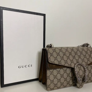 DIONYSUS GUCCI VÄSKA - Jättefin dionysus Gucci väska! Köpt ny och använts sparsamt och i fint skick. Endast mockan som blivit lite mörkare. Kvitto och box och dustbag finns. Pris kan diskuteras