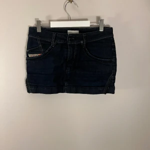 Dieselkjol från tidigt 00-tal/slutet 90-tal - Minikjol från diesel från tidigt 00-tal/ slutet 90 tal. I jättefint skick. W26, 76 cm i omkrets runt midja/höft.