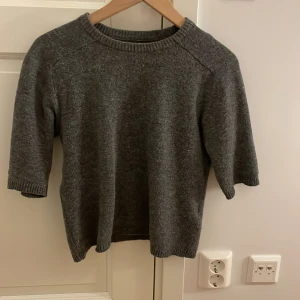 Stickad grå kortärmad  - Grå stickad kortärmad i 50%ull. Använd 1 gång. Köpt för 400kr säljer för 300kr❤️ärmen slutar precis innan armbågen börjar. Super fin tröja❤️