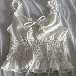Vit topp❤️ - Jättefin vit topp❤️ den är skjusterbar vid bröstet och har resår vi magen så jag skulle såga att storleken är flexibel. Säljer då den tycärr inte kommer till användning❤️ har köpt den second hand så vet tyvärr inte märket❤️