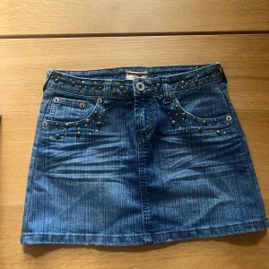 Blå jeanskjol - Blå jeanskjol med detaljer, storlek 12 men passar en xs