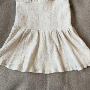 Super söt beige kort kjol, med en volang. Köpt för runt 250 kr på asos för ca 1 år sedan. Väldigt stretchig så passar nog större storlekar också. Knappt använd och i nyskick❣️ Pris är diskuterbart