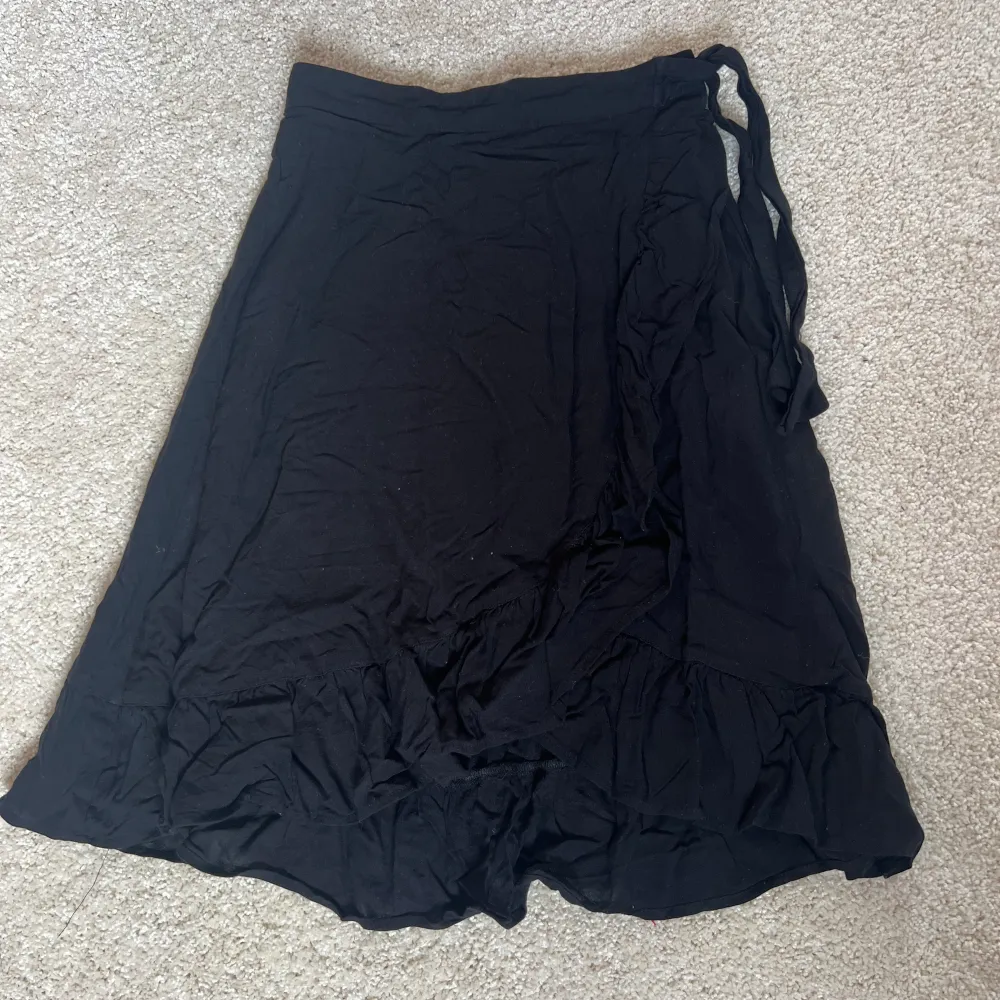 Svart kjol med lite volanger och knytning.  Vet inte vart den är ifrån eller storlek men skulle säga  en liten Xs/ XXS 💗. Kjolar.