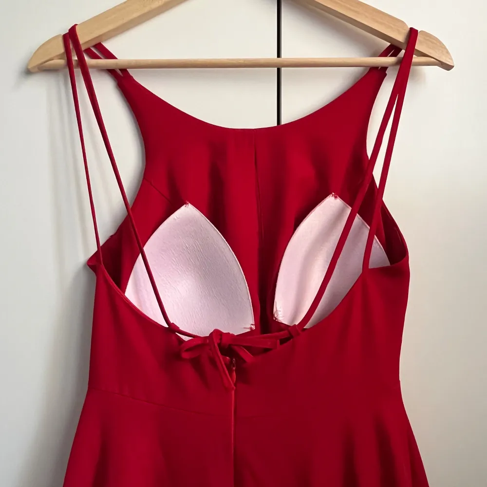 En röd balklänning (maxi) med snitt. Som ni kan se på andra bilden har klänningen en fin detalj med spets på bensnittet.. Klänningar.