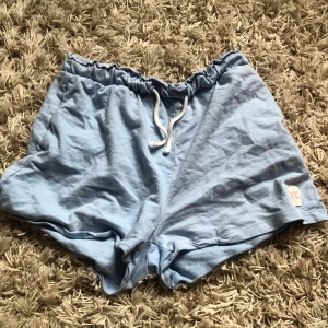 Blå shorts - Ljusblå mjukis shorts från H&M. Perfekt till sommaren då de är i slags linnetyg. 