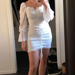 Klänning - Vit klänning i ett superskönt ”scrunch” material med puffar och volanger på ärmarna🤍 perfekt studentklänning eller bara till sommaren🥳 Helt oanvänd, prislapp kvar! Storlek 38💕