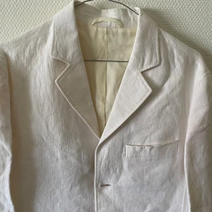 KAVAJ - Vit kavaj i bomull/linne  från BZT  Fin sommarkavaj för ung man i   medium  storlek Märkningsetiketten saknas Finns i Fredhäll