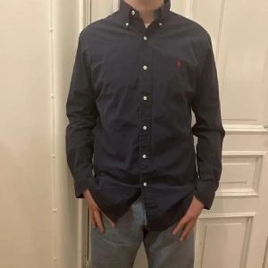 Ralph Lauren skjorta - En snygg Ralph Lauren skjorta i mörkblått som är perfekt för våren och är i bra skick. S passar även M Hör av dig vid fundering