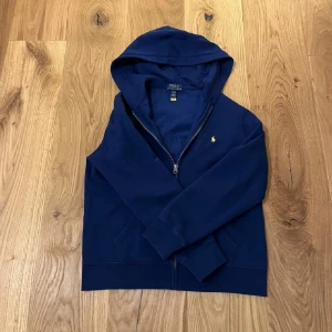 Zip Hoodie Polo Ralph Lauren  - Säljer denna feta zip hoodien från Polo Ralph Lauren. Tröjan passar mig som är 175 cm lång jätte bra! Plagget skick är 9/10 som eftersom de används fåtal gånger. Nypriset för tröjan var 1200kr, säljer den för 700kr. Skriv gärna vid fler fler frågor?