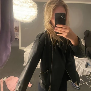 Skinnjacka  - Jacka i konstläder, oversize med skärp. Från Nelly. Slutsåld.  