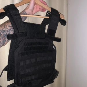 Tactical väst/vest svart - ”Tactical” väst som ser ut som en skyddsväst.  Kan användas hur man själv vill. Fraktas med Postnord över hela Sverige eller hämtas på plats.