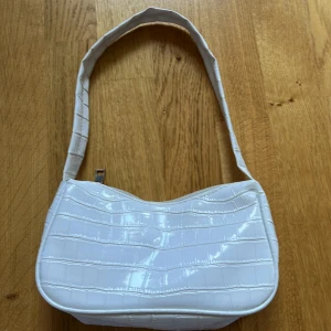 Vit axelväska - Vit axelväska med krokodil likande material. 