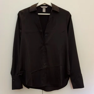 Satinskjorta - Svart satinskjorta med knappar. Köpt ny och använd max 5 gånger så bra skick.💖🌷