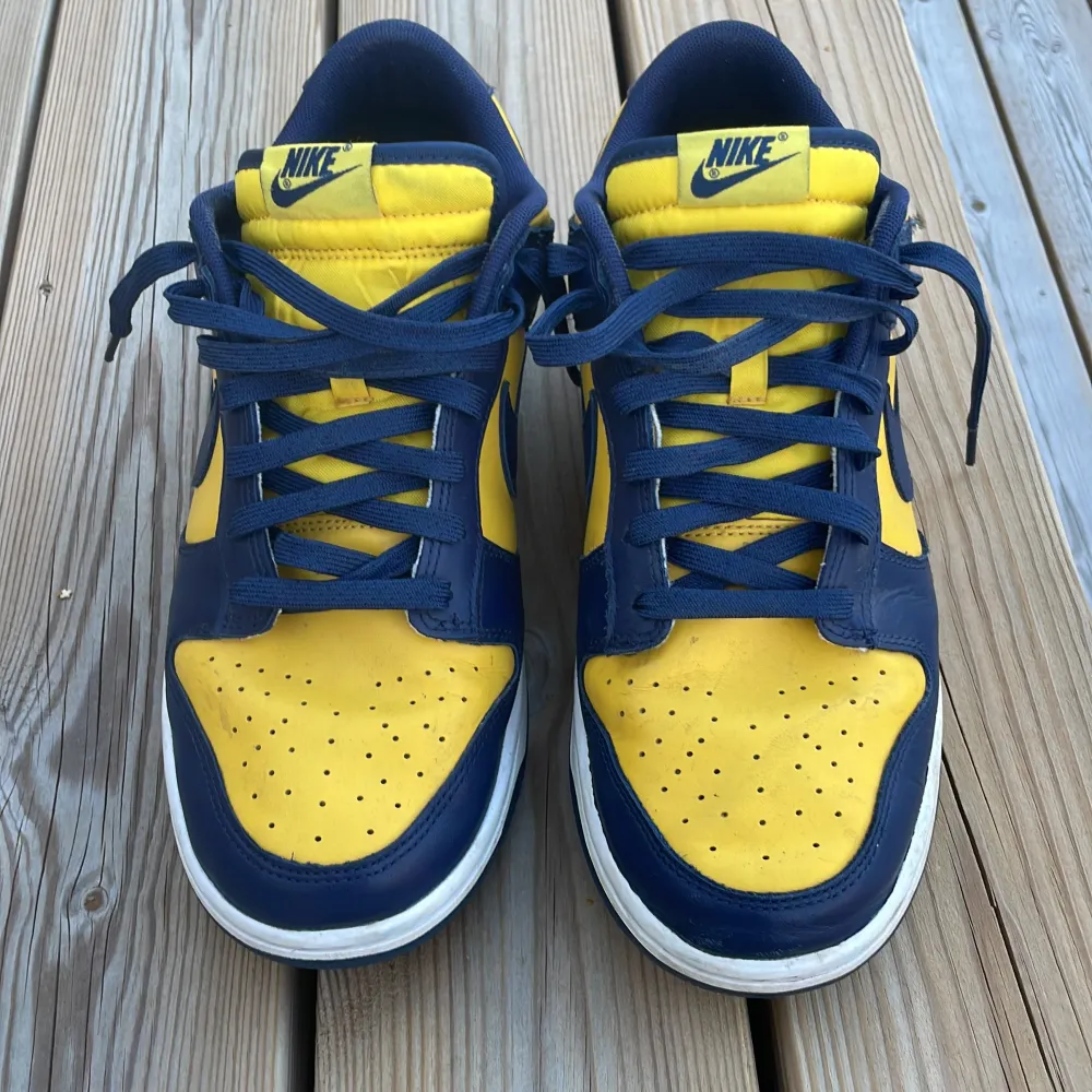 Detta är ett par Nike Dunk Low michigan skor i blå och gul färg. Dem är gjorda i färgat läder. Nypris: 1200kr. Saknar låda. Pris kan diskuteras . Skor.