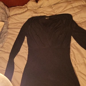 Ginatricot klänning - Tajt och urringad klänning i svart glansigt material. Går till lite över knäna på mig som är 167