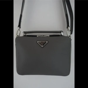 Prada Saffiano - Leather shoulder bag - Finns inte längre tillgängliga med läderrem och har därför ökat i pris.  Höjd: 16 cm Bredd: 23,5 cm  Längd: 6,5 cm