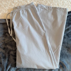 Blå randiga pyjamasbyxor - Pyjamasbyxor från HM. Endast använda en gång men dom är tyvärr lite korta på mig. Finns även en matchande skjorta som jag ev kan tänka mig och sälja ☺️