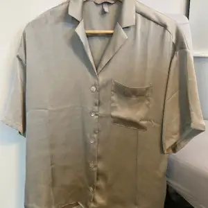 Blus / skjorta med kort ärm i storlek XS. Köpt från H&M. I mycket fint skick. 
