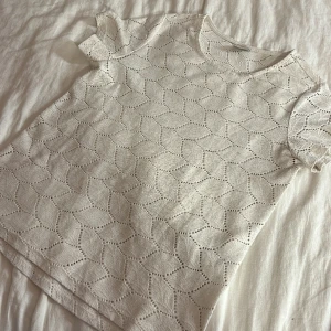 Vit t-shirt  - Vit t-shirt med blad ish mönster, jätte söt!