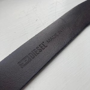Diesel bälte - Säljer mitt gamla dieselbälte eftersom jag växt ur det. Storleken är 80cm men det är bra att veta att hela bältet är 98cm från bucklan till spetsen och 32 mm brett. Den enda defekten är att det är en aning böjt av användningen. Ställ gärna frågor💬