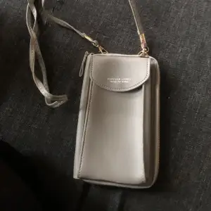 Minimalistisk axelväska i grå färg. All-Match Crossbody-väska för mobiltelefoner, mångsidig myntväska med avtagbar rem ..i nyskick