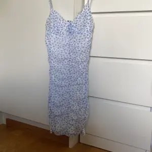 En vit blå blommig klänning från hm som bara använts 2 gånger💕