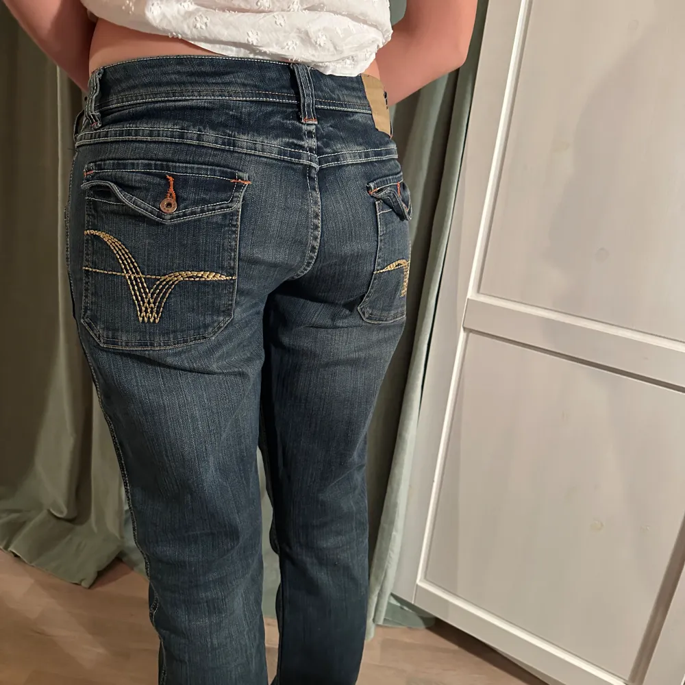 Lågmidjade mörkblå jeans med detaljer och design. Jeansen är raka i modellen.. Jeans & Byxor.