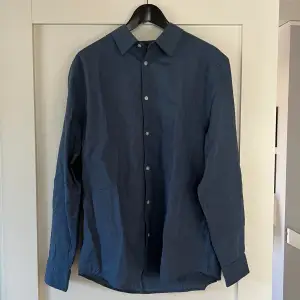 Blå Linneskjorta. Är helt ny och aldrig använd. Väldigt schysst nu till sommaren.