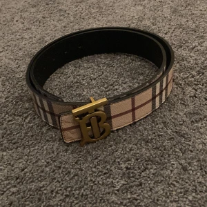 Burberry Bälte - Burberry bälte som endast har använts ett fåtal gånger. Inga problem alls med det och du får även med dustbagen och hålslagaren till bältet. Det går att vända på bältet som på bilderna. Precis är absolut justerbart.
