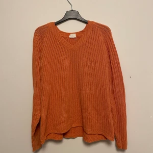 Orange stickad tröja - Tunn stickad tröja. Aningens urtvättad färg så lite mer av en retro-stil!  Storleken säger XL men tror det är ett gammalt mått, skulle mer säga att den ligger mellan M-L :)