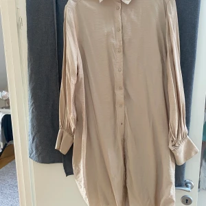 Skjortklänning  - Skjortklänning i viscose och polyamid  Beige / guld färgad 