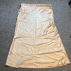 Ahlvar Gallery strl L-XL  - Siden kjol i creme färg från Ahlvar, modell Hanna.  Strl XL - men passar L. Bortklippt  strl lapp och tvättråd. Kemtvätt. Resår i midjan. Aldrig använd 