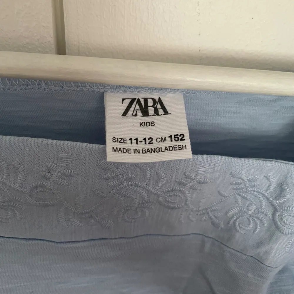 Säljer denna t-shirten/ blusen från zara-kids som är i en ljusblå färg med fina detaljer. Helt ny, bara tvättad. Passar perfekt till sommarn🩵. T-shirts.