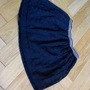 Söt kjol - Det är en söt mörkblå/ svart kjol med glitterrandigt skärp från Tommy Hilfiger, den är i storleken 128.