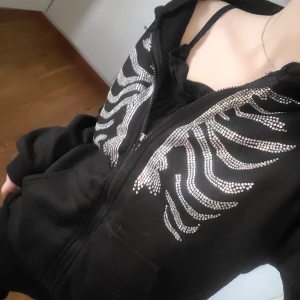 Skelett zip up - En svart zip up med skelet i små stenar. Super mjuk! Säljer för att det inte är min smak längre.