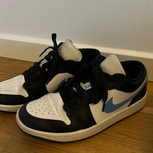 Jordan 1 low - Säljer dessa snygga Nike jordan 1 low skorna i denna super snygga modell med ljusblåa detaljer🩵🩵 skorna är använda men inget märkvärdigt som syns! 