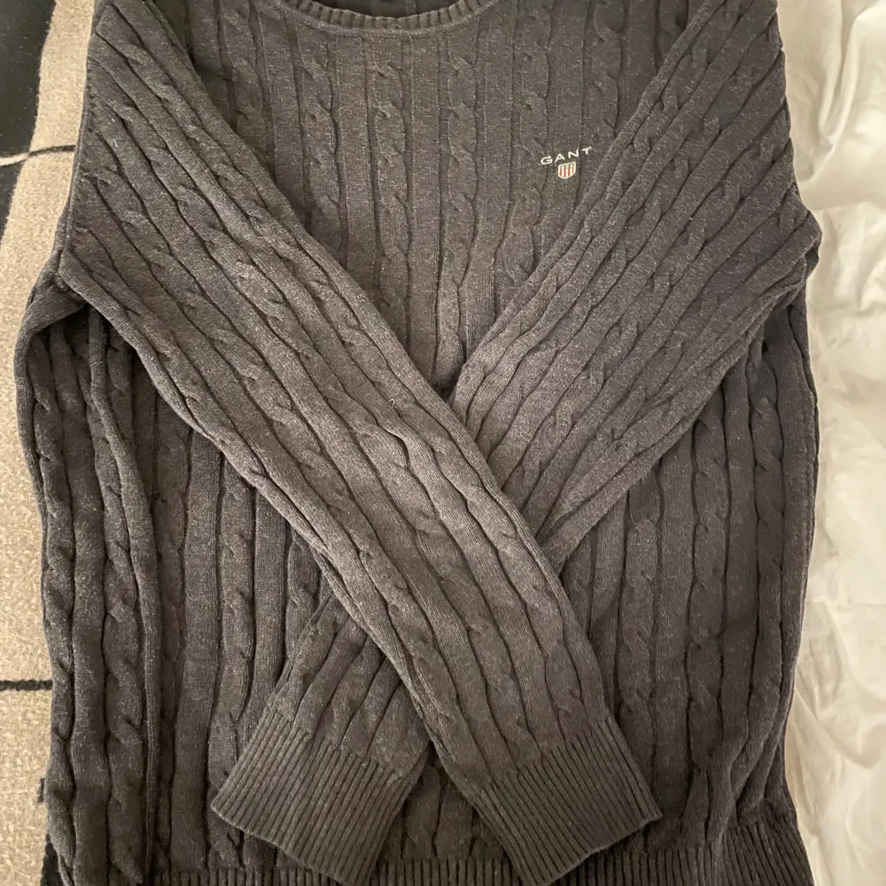 En stickad mörkgrå tröja från gant. Storlek XL men känns som en stor M. Använd men i bra skick.. Tröjor & Koftor.