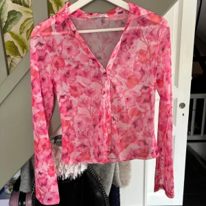 Stradivarius topp - Genomskinlig Jättefint tryck med blommor 🌸  Köpt för 229kr  Jag säljer för 150kr  Slutsåld på ASOS Jättestretchig så passar nog M också
