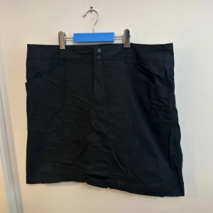 Svart Byxkjol i nyskick storlek 42 - Storlek 42. Två djupa fickor fram. Shorts med kjol från four-d i nyskick.   Mått  Midjebredd 45cm Längd från midja 47cm