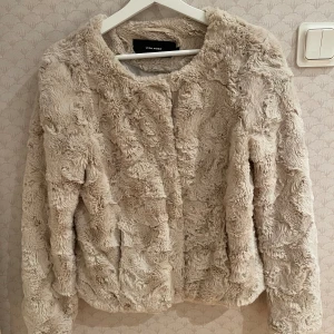 Beige fuskpälsjacka - Fin beige vårjacka i fuskpäls. Sparsamt använt och i toppskick. 