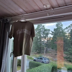 Stilren olivgrön t-shirt - En lite oversized t-shirt. Funkar perfekt för mig som är 184cm, nästan för liten.
